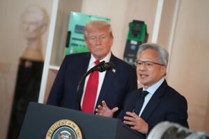 Donald Trump standing beside a speaker at the White House podium during a press event, listening attentively.